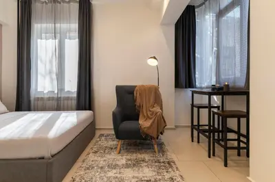 a bedroom with a bed and a chair and a desk at Victor Hugo Studio in Sofia