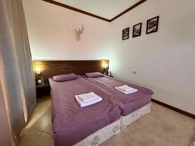 a bedroom with a purple bed with two towels on it at St Ivan Rilski SPA Studio in Bansko