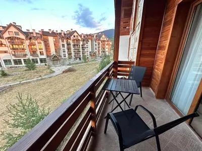 a balcony with a table and chairs and a view of buildings at St Ivan Rilski SPA Studio in Bansko