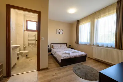 a bedroom with a bed and a bathroom with a toilet at Rila Hills in Samokov