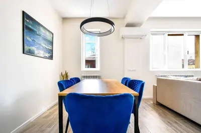 a dining room with a table and blue chairs at Skyline View - Very Central - Metro - Washer&Dryer in Sofia