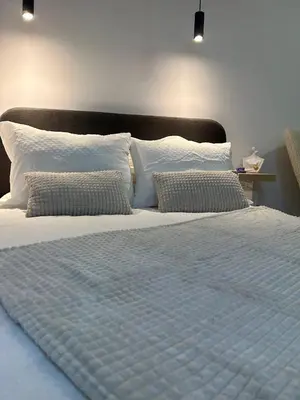 a large white bed with pillows on top of it at Pirotska Modern Room in Sofia