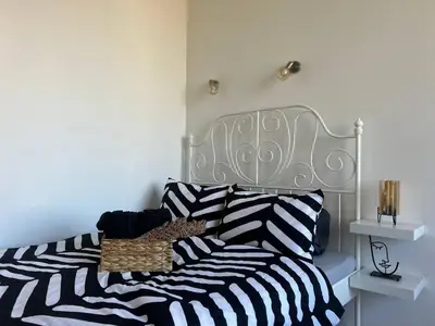 a bed with a black and white striped comforter at Pirostka Vintage Room in Sofia