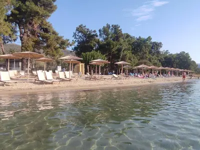 a group of chairs and umbrellas on a beach at Magic House in Thassos Island Scala Rachoni in Blagoevgrad