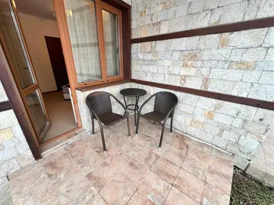 a patio with two chairs and a table and a window at Luxury apartments in Downtown Residential Complex in Bansko