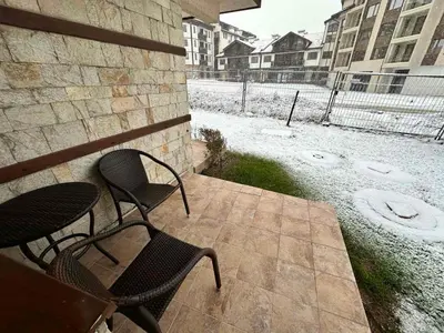 two chairs and a table on a patio with snow at Luxury apartments in Downtown Residential Complex in Bansko