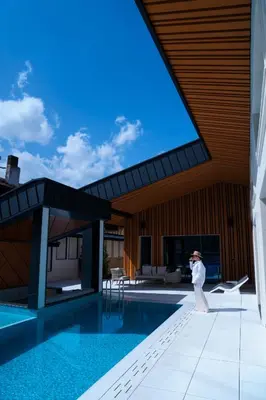 a person standing next to a swimming pool at Alpine Bell Villa in Banya