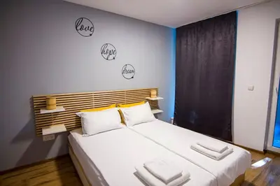 a bedroom with a large white bed with three pillows at Аpartment near Sofia airport in Sofia