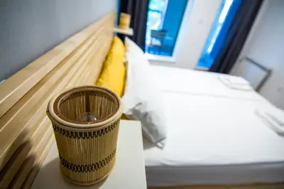 a cup sitting on a table next to a bed at Аpartment near Sofia airport in Sofia