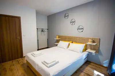 a bedroom with a large bed with two towels on it at Аpartment near Sofia airport in Sofia