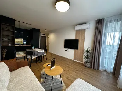 a living room with a couch and a table at 1BR Modern condo near the University in Sofia