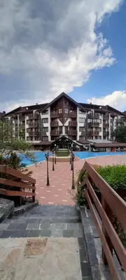 a large building with a pool in front of it at Belvedere K203 in Bansko