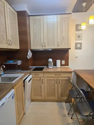 a kitchen with wooden cabinets and a table and chairs at Belvedere K203 in Bansko