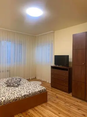 a bedroom with a bed and a dresser and a television at Lena in Sofia