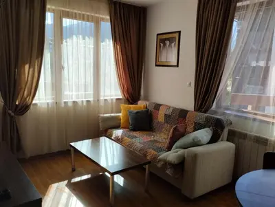 a living room with a couch and a coffee table at Апартаменты в Belvedere in Bansko