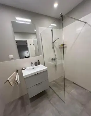 a bathroom with a sink and a shower with a mirror at Boston Cozy Elegant Family Apt w Parking Near NSA in Sofia
