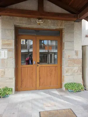 a wooden door of a building with a person standing behind it at One bedroom Apartment in Bansko