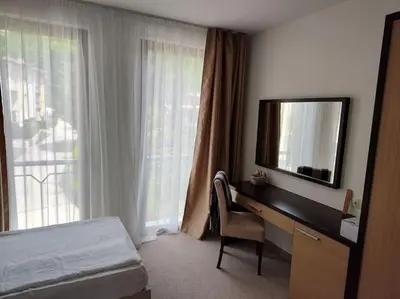 a bedroom with a desk with a television and a bed at Modern 2BDRM in 5* Resort & pool in Sandanski