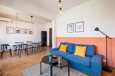 a living room with a blue couch and a table at Orange friendly apartment near Vitosha blvd in Sofia