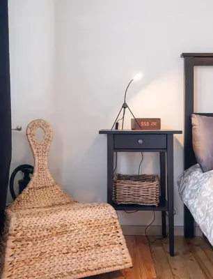 a bedroom with a bed and a table with a clock on it at Orange friendly apartment near Vitosha blvd in Sofia