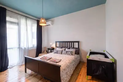 a bedroom with a bed and a large window at Orange friendly apartment near Vitosha blvd in Sofia
