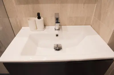 a white sink in a bathroom with two toilets at Top Center Designer Apartment in Sofia