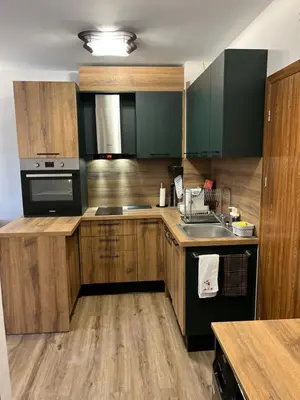a kitchen with wooden cabinets and a sink at Elizi winter apartments Pamporovo in Pamporovo