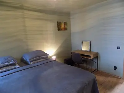 a bedroom with a bed and a desk with a laptop at La'Vista in Smolyan