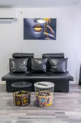 a black couch with two end tables in a room at PARADISE RELAX APARTMENT in Bansko