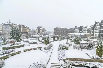 a garden covered in snow in a city at PARADISE RELAX APARTMENT in Bansko