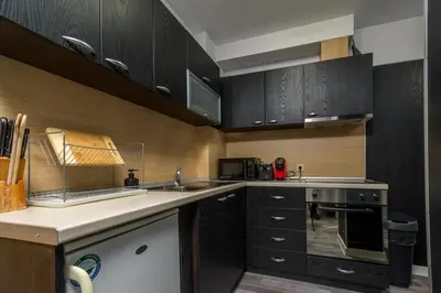 a kitchen with black cabinets and a counter top at PARADISE RELAX APARTMENT in Bansko