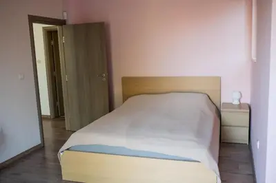 a bedroom with a bed with a wooden head board at Вила Маунтайн Вю in Brestnik
