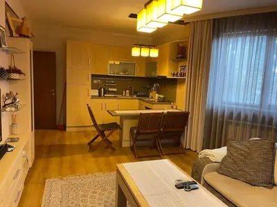 a living room with a couch and a kitchen at Nikol 3 SPA CLUB BOR in Velingrad