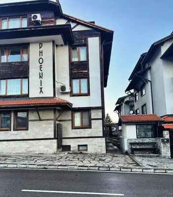 a building on the side of a street at Уникален апартамент с изглед към планината in Bansko