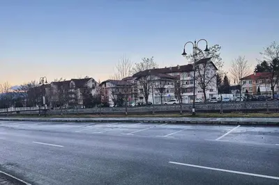 an empty city street with buildings and a fence at Уникален апартамент с изглед към планината in Bansko