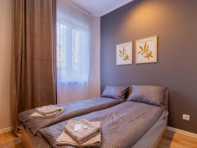 a small bedroom with a bed with towels on it at Eiffel Elegance - Stylish Sofia Apartment in Sofia