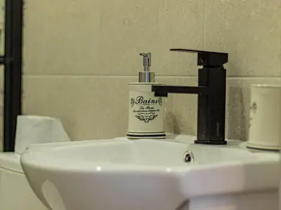 a bathroom sink with a faucet and a cup on it at Eiffel Elegance - Stylish Sofia Apartment in Sofia