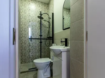 a bathroom with a toilet and a sink and a shower at Eiffel Elegance - Stylish Sofia Apartment in Sofia