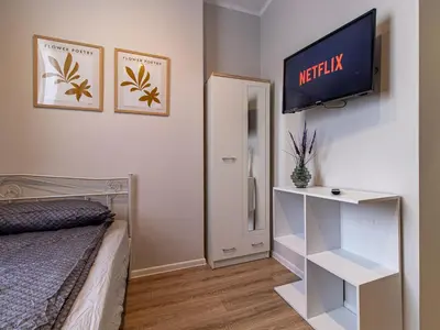 a bedroom with a bed and a tv on a wall at Louvre Loft: Charming Studio in Central Sofia in Sofia