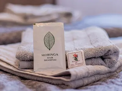 a pack of moringa hair shampoo sitting on a pile of towels at Louvre Loft: Charming Studio in Central Sofia in Sofia