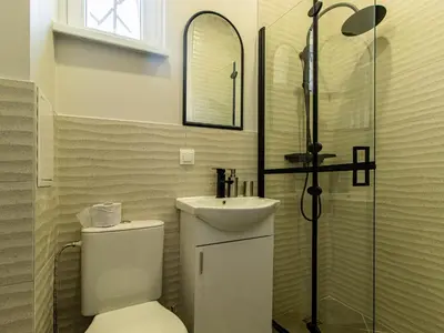 a bathroom with a toilet and a sink and a shower at Louvre Loft: Charming Studio in Central Sofia in Sofia