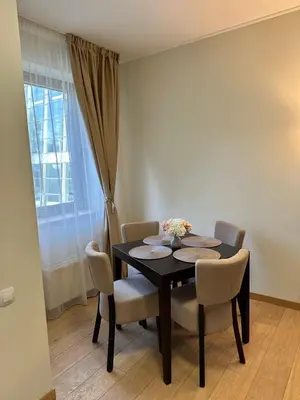 a dining room with a table and chairs and a window at Lodge Euphoria Studio in Borovets
