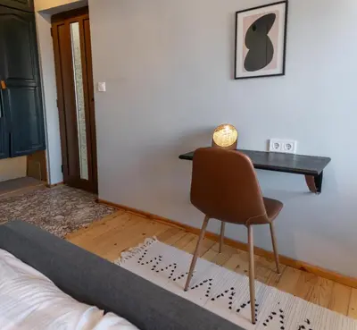a bedroom with a desk and a chair next to a bed at Eight Rooms Bansko in Bansko