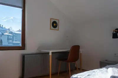 a bedroom with a desk and a chair next to a bed at Eight Rooms Bansko in Bansko