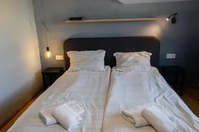 a bedroom with a bed with two towels on it at Eight Rooms Bansko in Bansko