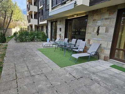 a patio with a table and chairs in front of a building at TERRA KOMPLEX D3 - Private apartment - Golf, Skiing & SPA in Razlog