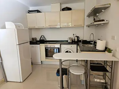 a kitchen with white appliances and a white table at TERRA KOMPLEX D3 - Private apartment - Golf, Skiing & SPA in Razlog