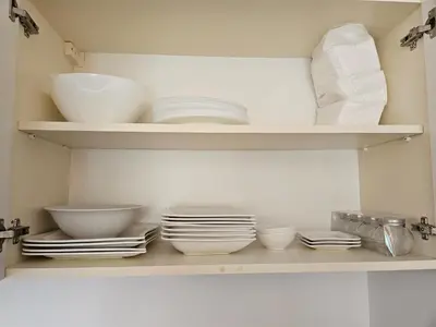 a kitchen shelf with bowls and plates on it at TERRA KOMPLEX D3 - Private apartment - Golf, Skiing & SPA in Razlog