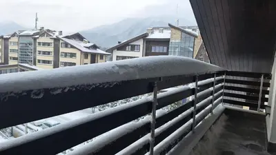 a snow covered railing on a balcony with buildings at Aspen Suites A403 - Sky & Stars Dreamers in Razlog