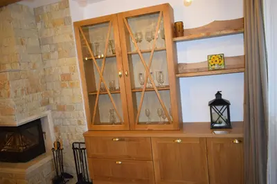 a cabinet with glasses in it next to a fireplace at Супер луксозен апартамент в Winslow in Bansko